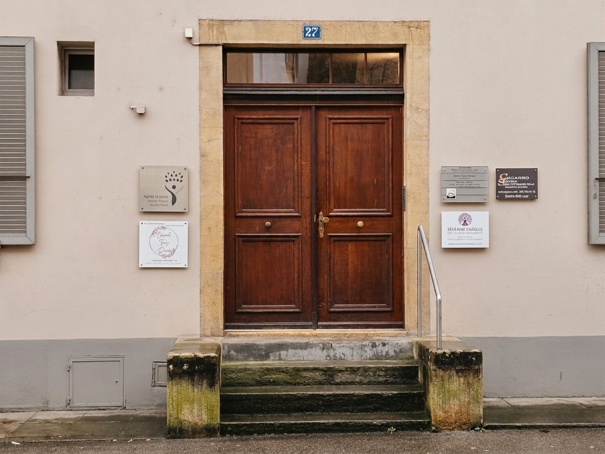Entrée du cabinet de Séverine Chasles, porte en bois au numéro 27 de la Rue de l'Évole à Neuchâtel